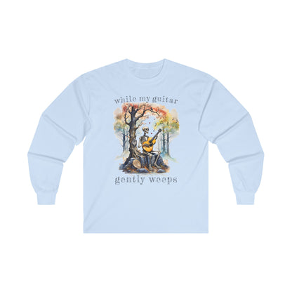 This gothic skeleton long sleeve t-shirt featuring a grisly guitarist jamming on an acoustic guitar in a haunting watercolor forest is a stunning tongue-in-cheek homage to the Beatles music. This haunting design looks great on this light  blue Gildan unisex heavy cotton long sleeve t-shirt.