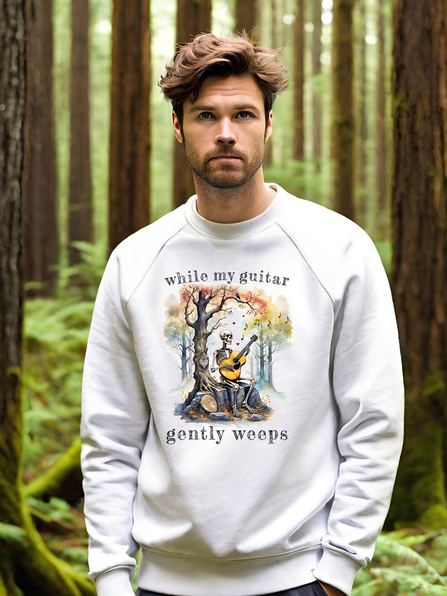 This gothic skeleton sweatshirt featuring a grisly guitarist jamming on an acoustic guitar in a haunting watercolor forest is a stunning tongue-in-cheek homage to the Beatles music. This  cool dude looks great in this Gildan unisex heavy cotton sweatshirt