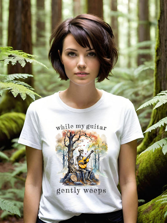 This gothic skeleton T-shirt featuring a grisly guitarist jamming on an acoustic guitar in a haunting watercolor forest is a stunning tongue-in-cheek homage to the Beatles music. This stylish lady looks great in this Gildan unisex heavy cotton t-shirt.